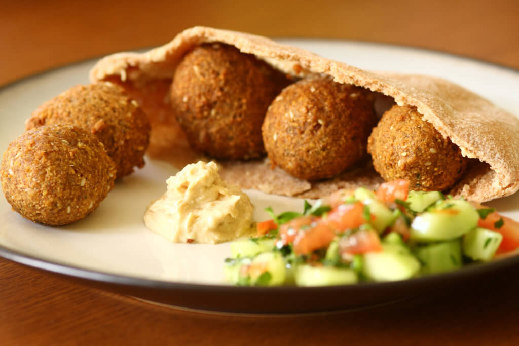 Falafil in a pita with hummus and cucumber tomato salad.