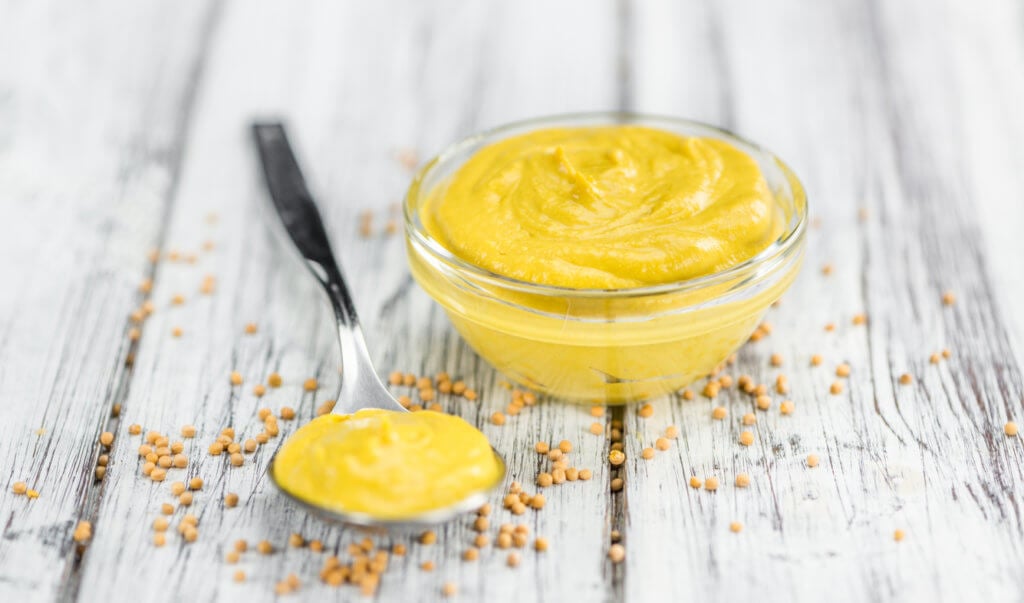 Mustard as high detailed close-up shot on a vintage wooden table.