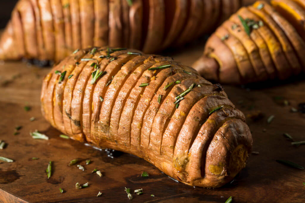 Homemade Organic Hasselback Sweet Potato with Fresh Herbs.