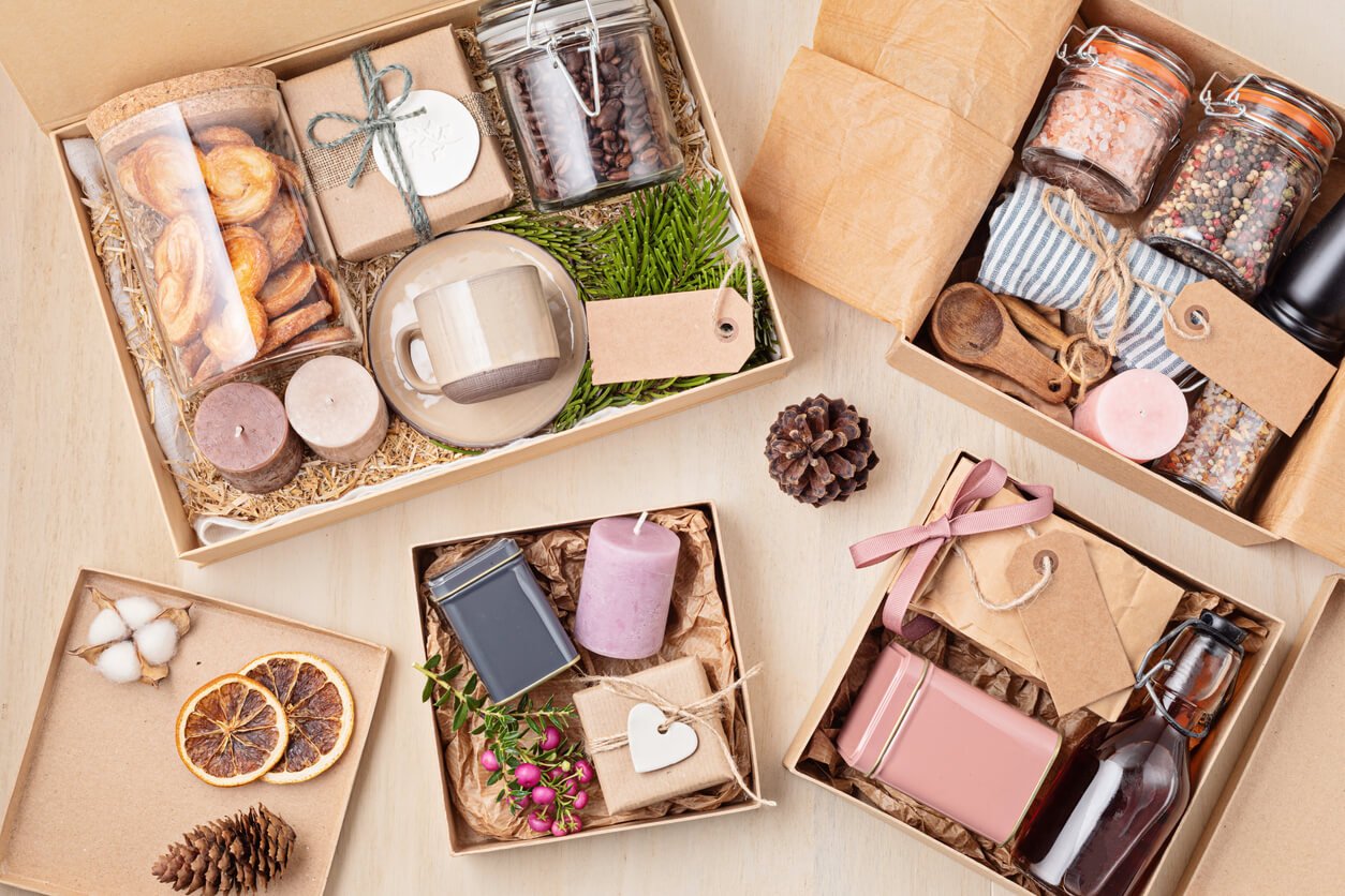 Preparing care package, seasonal gift box with coffee, cookies, candles, spices and cups