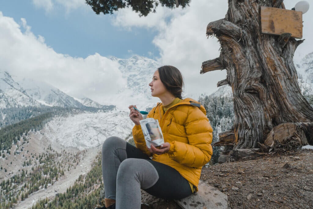 Woman eating dried meal while hiking