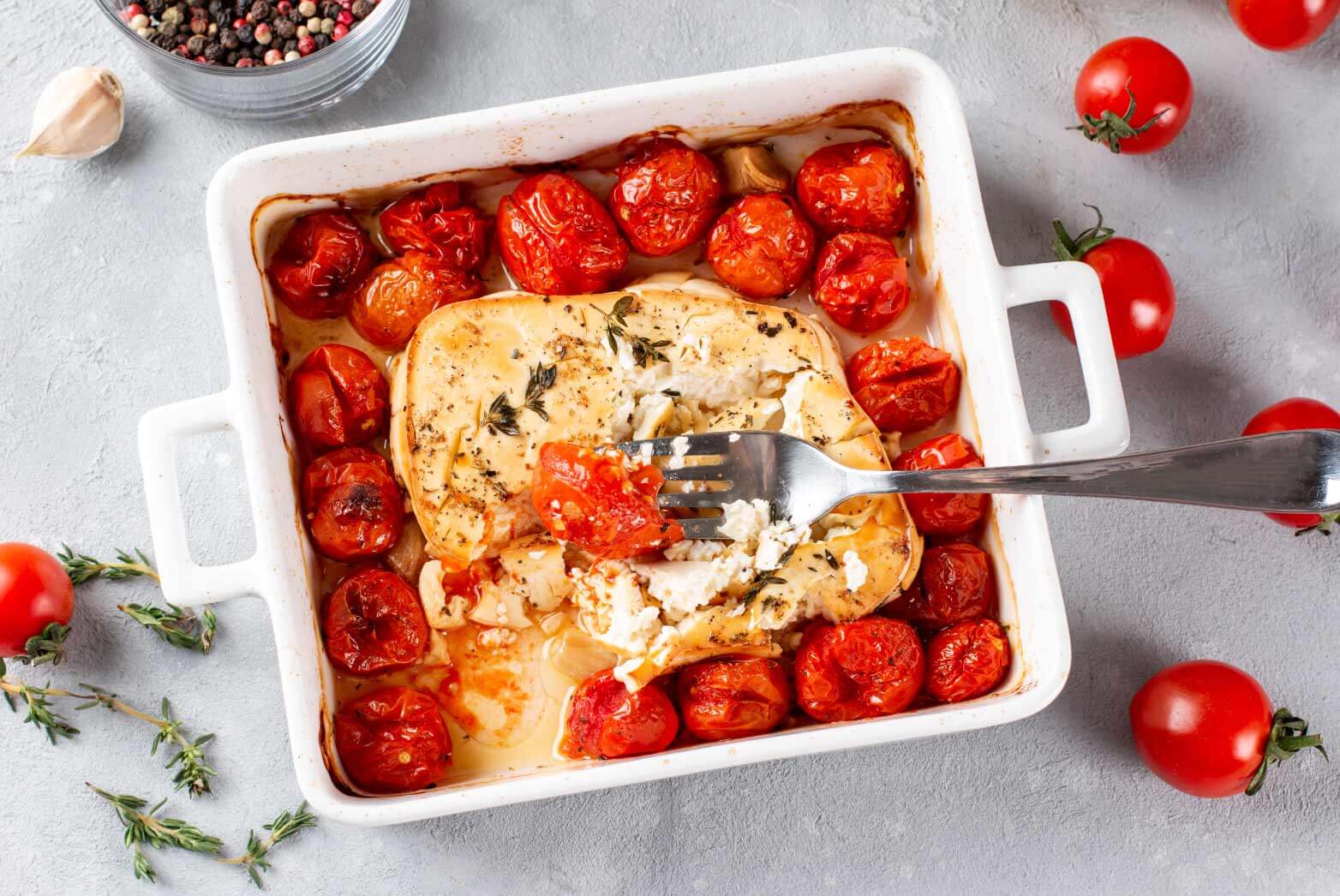 Close up of a baked feta pasta dinner for two in a white porcelain container