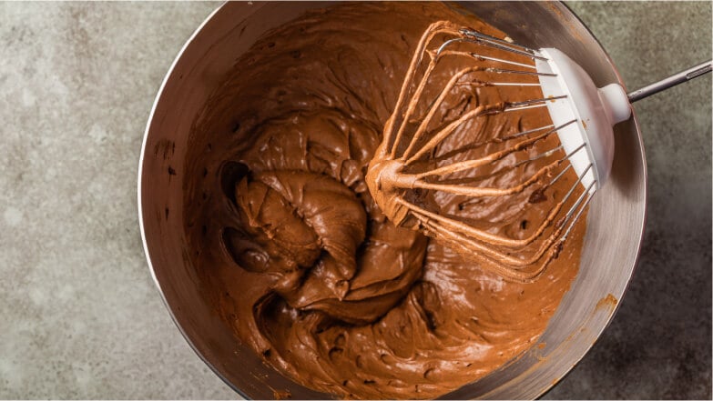 Mixing ingredients in a glass mixing bowl to bake chocolate bundt cake with  chocolate frosting Stock Photo - Alamy