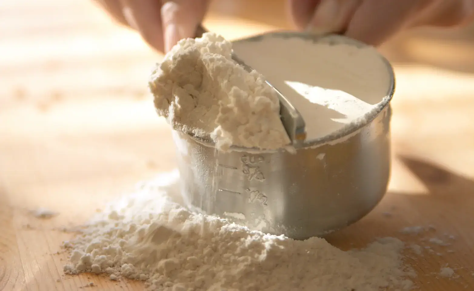 Person measuring the pounds to cups of all-purpose flour.