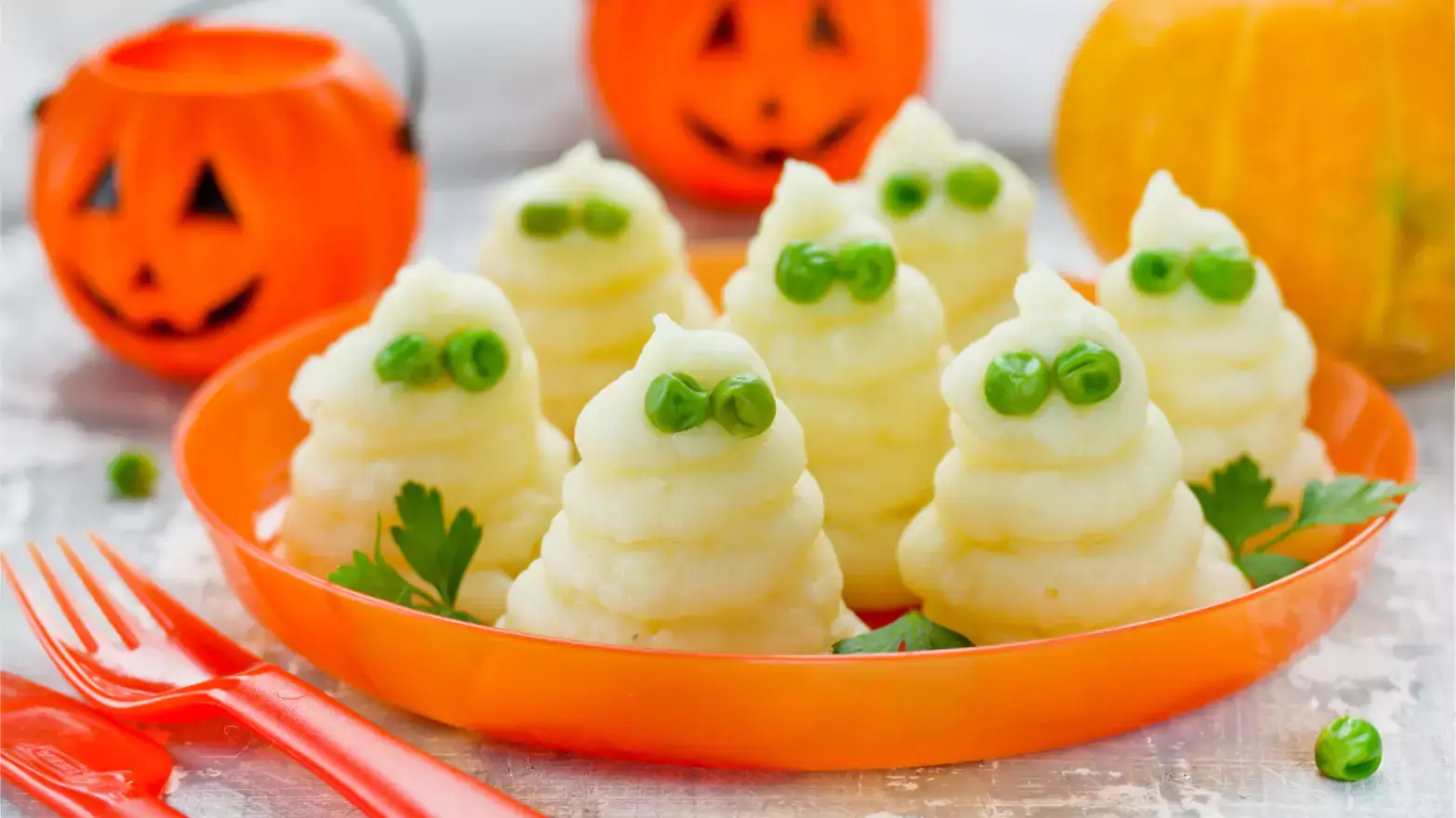 Mashed potatoes shaped into ghosts with peas for eyes