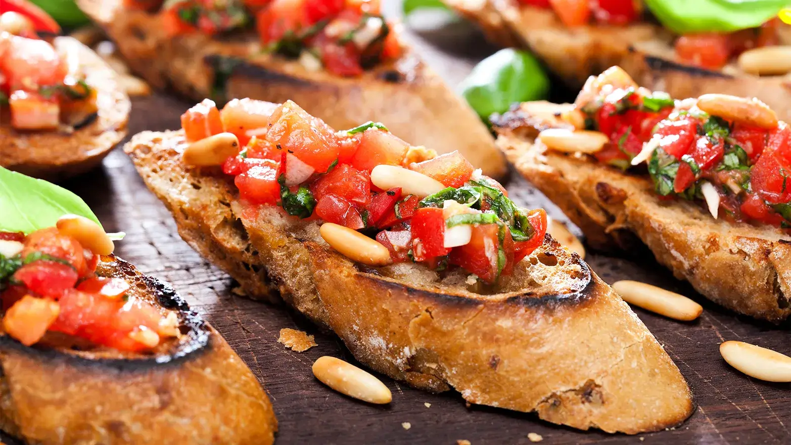 toasted bread slices topped with roasted cherry tomatoes and pine nuts.