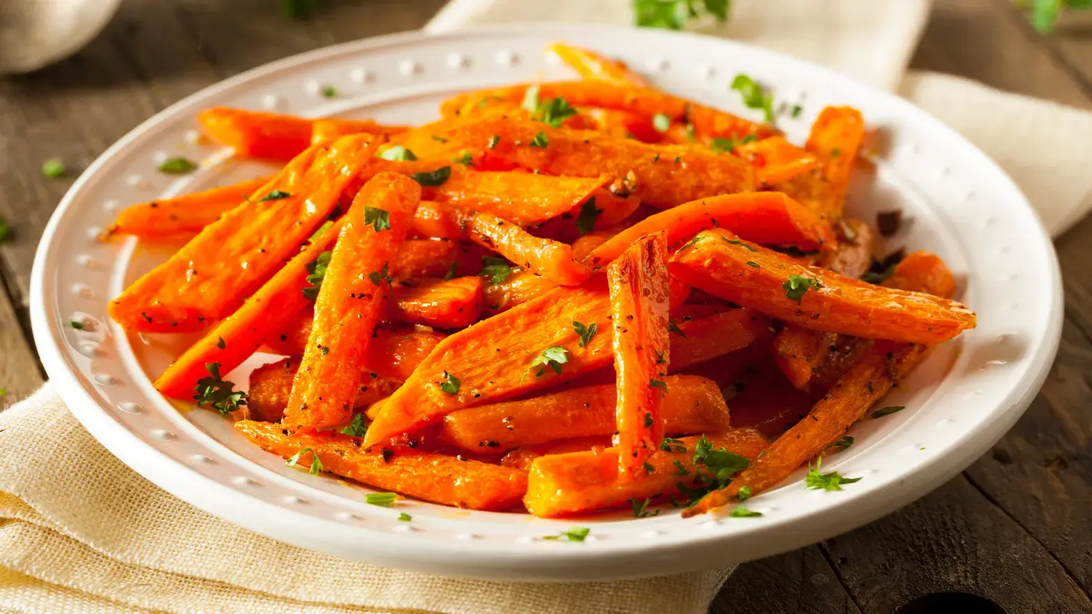 Roasted carrots cut into spears on a serving plate. 