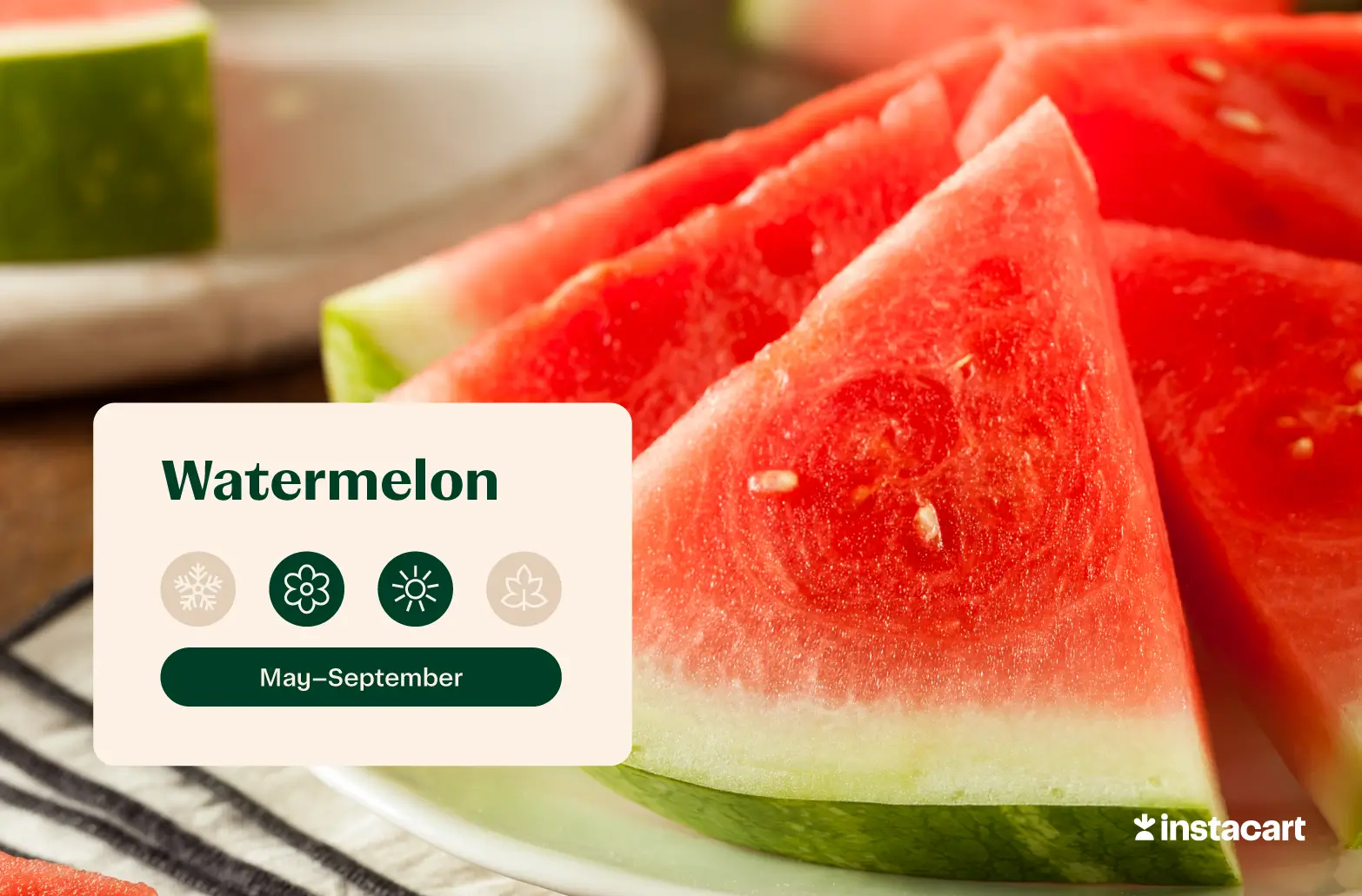 A round watermelon on a wooden surface with wedges cut out and sitting beside it.