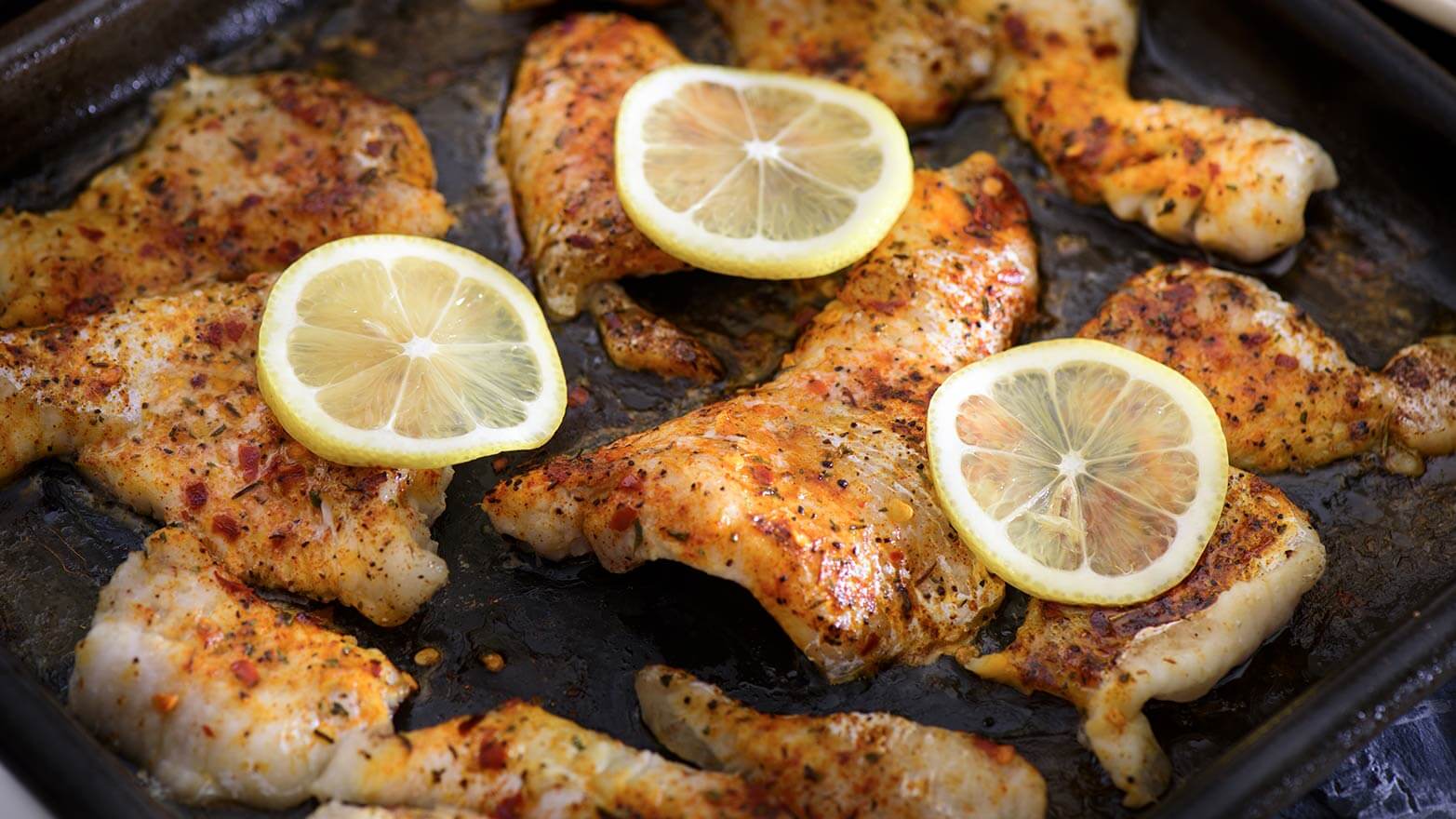 Baked catfish topped with slices of lemon