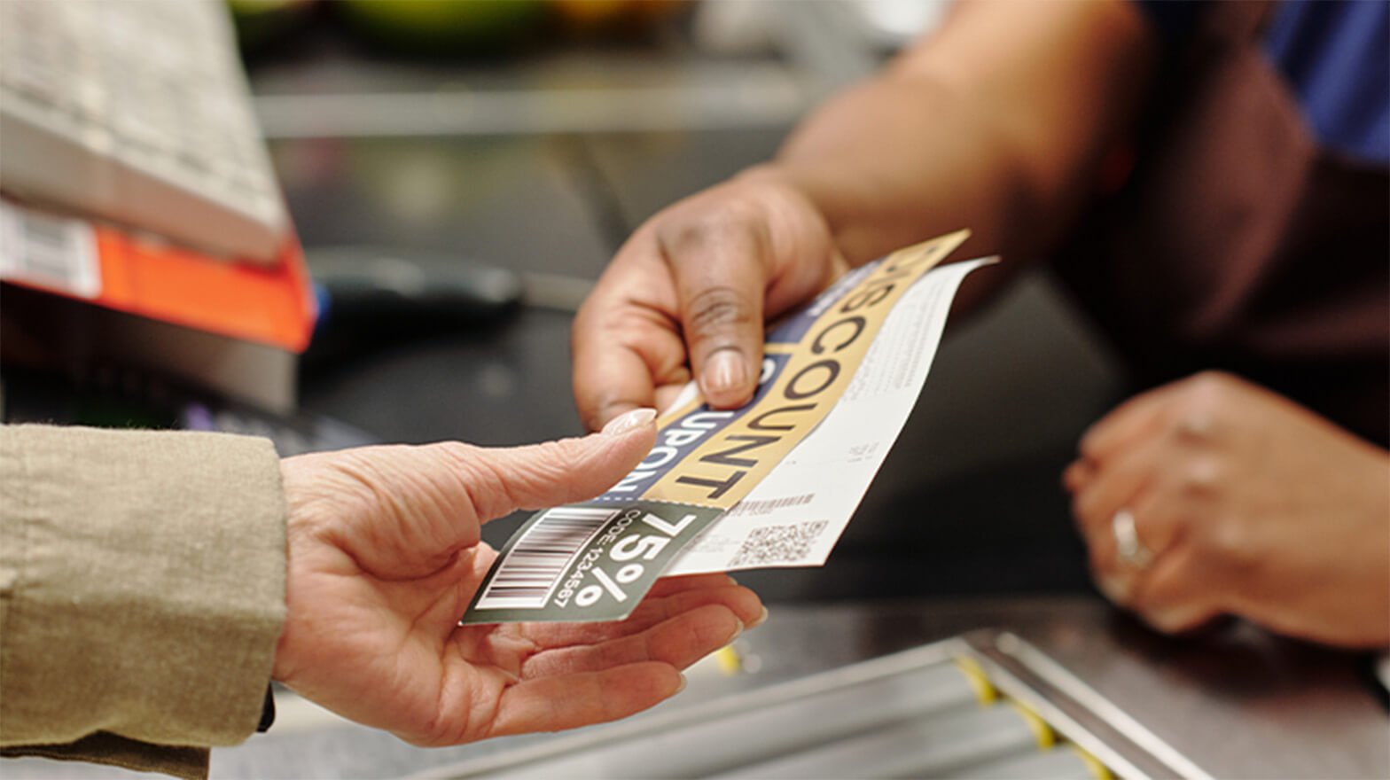 A person saving money on groceries by paying with coupons