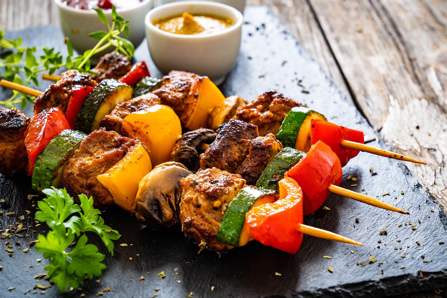 Three pork skewers on a table.