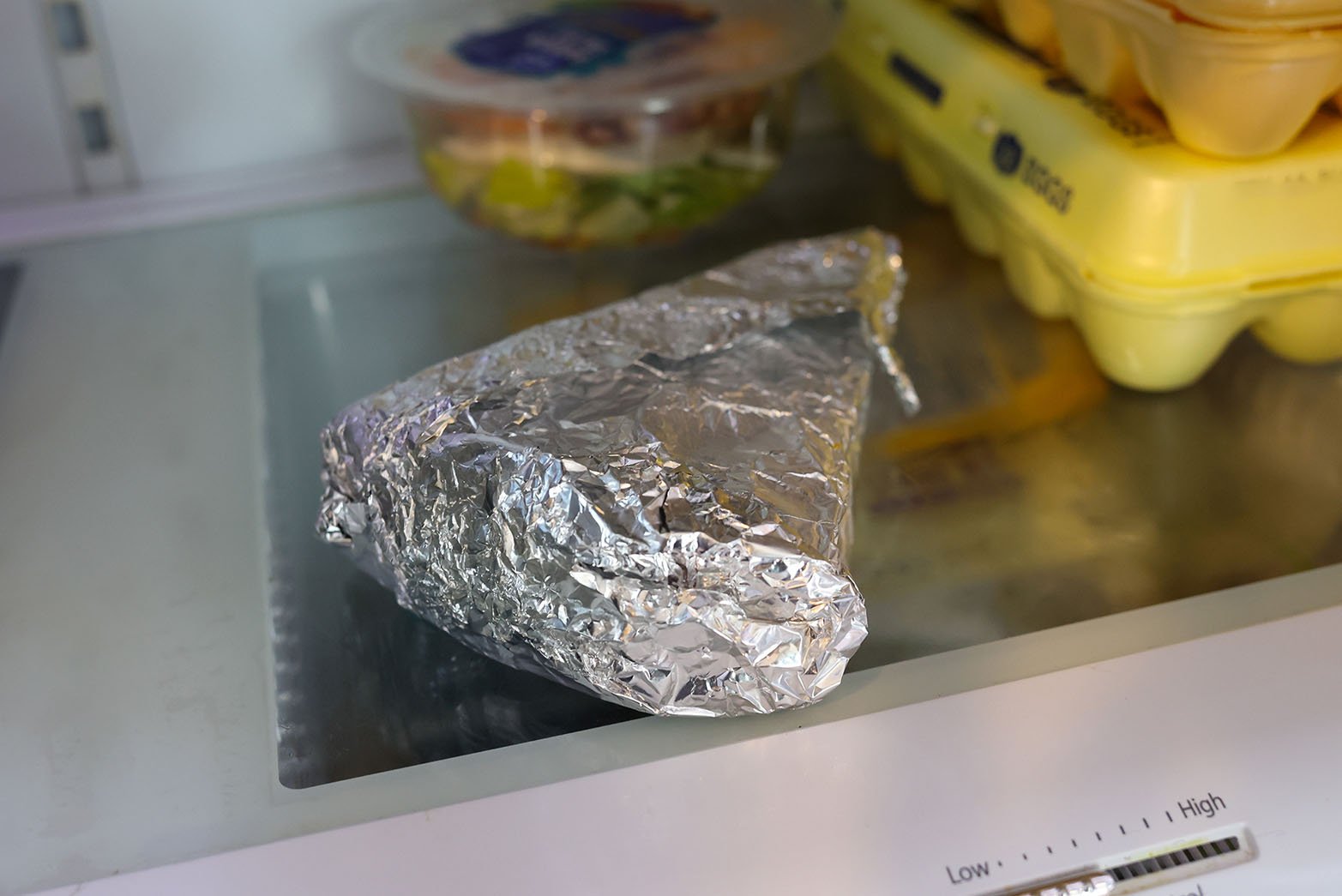 Pizza wrapped up and stored properly in fridge to ensure freshness.