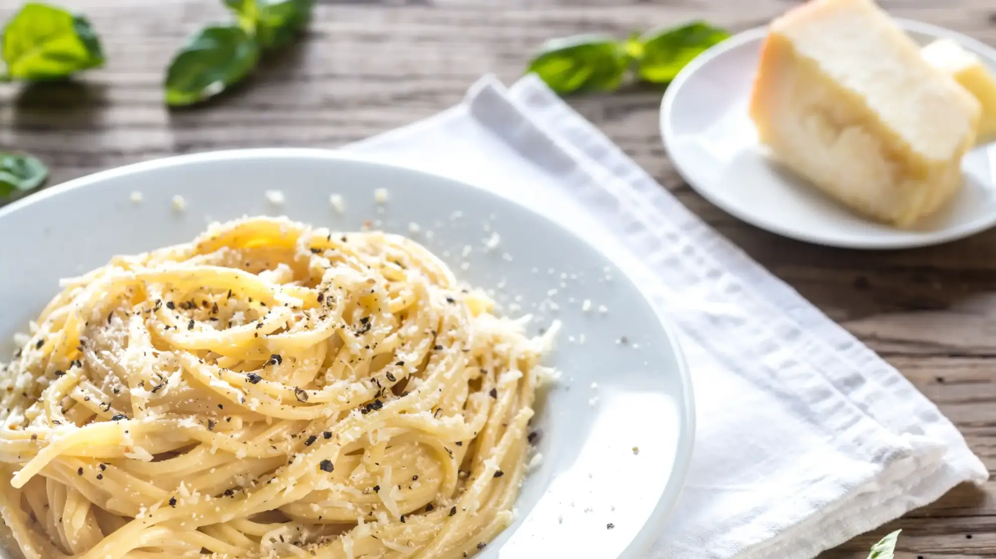 Bowl of pasta topped with cheese.