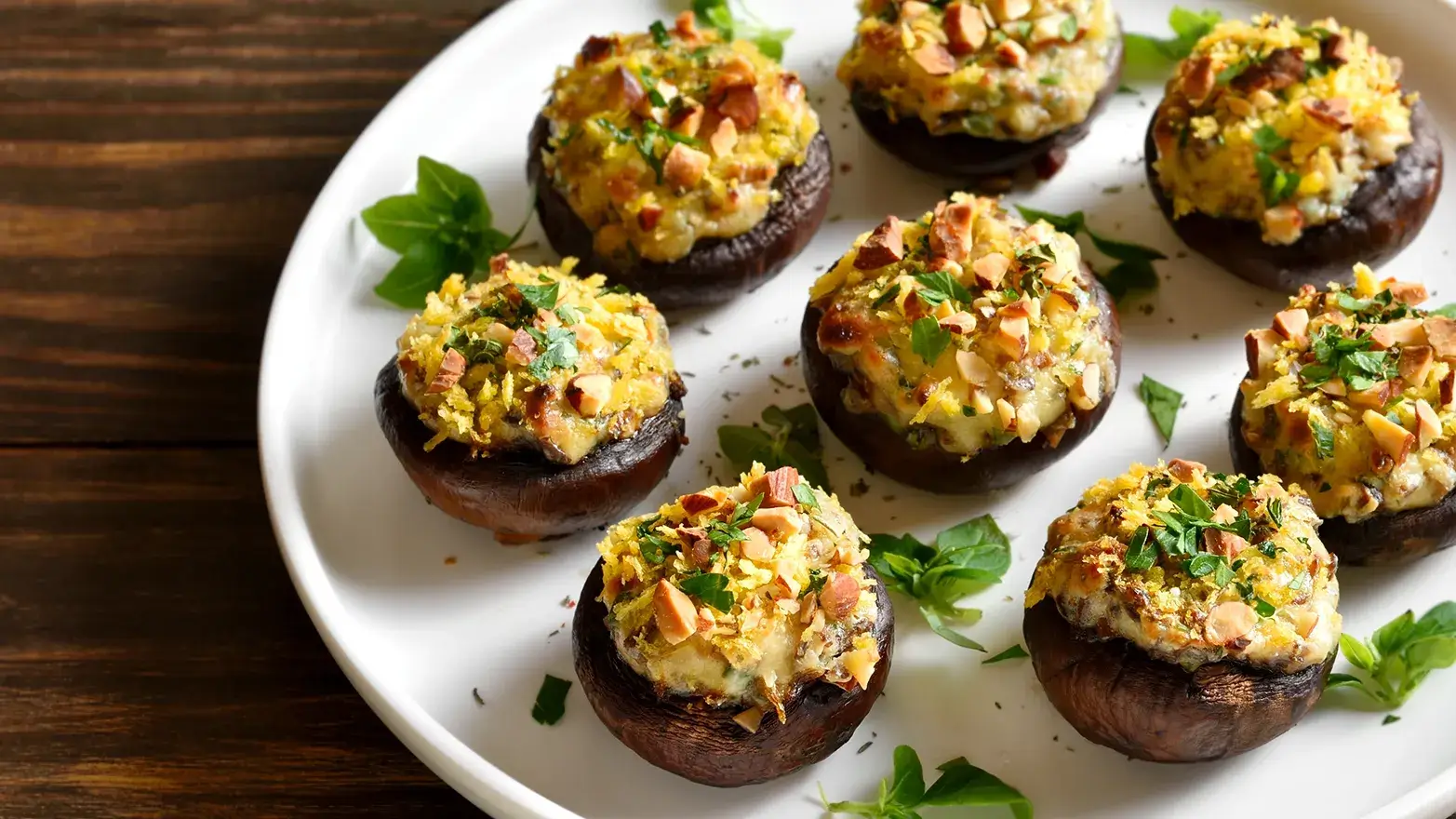 Stuffed mushrooms on a white plate ready to be served at a super bowl party