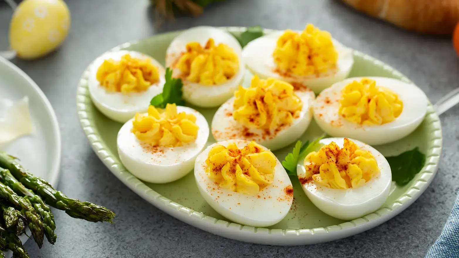 A plate of deviled eggs topped with seasoning