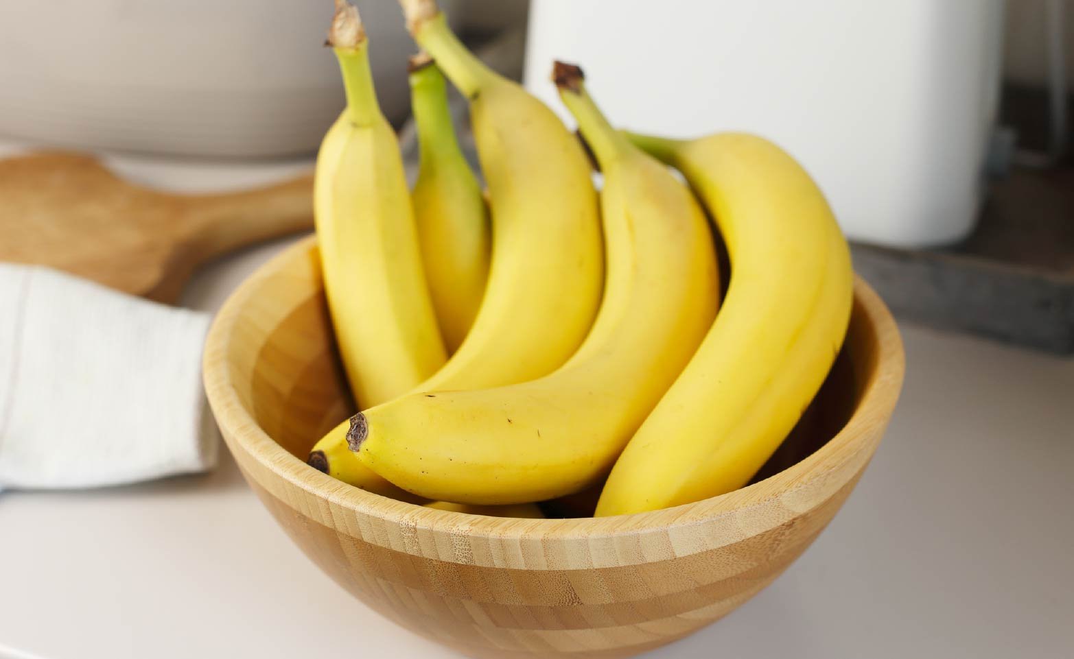 Five bananas ripening overnight in a large bowl on kitchen counter