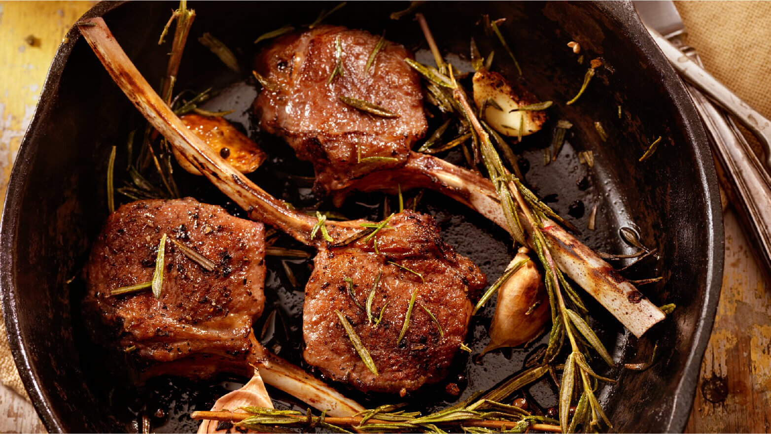 Lamb chops in a baking dish with fresh herbs