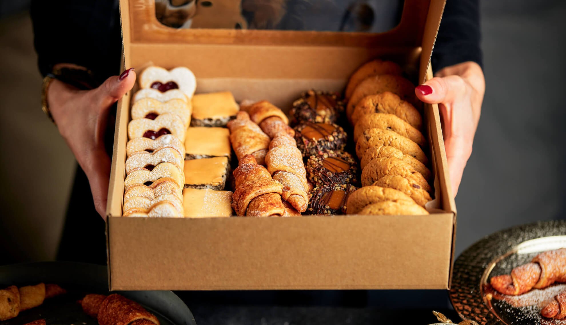 A person opening a box of bakery goods that were sent to them from a person out-of-state using Instacart.